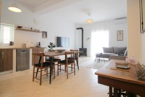 a kitchen and living room with a table and chairs at Jasmine Sol Retreat in Delvinë
