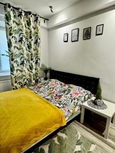 a bedroom with a bed with a yellow comforter at Apartment Warsaw Powiśle in Warsaw