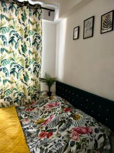 a bedroom with a bed with a floral bedspread at Apartment Warsaw Powiśle in Warsaw
