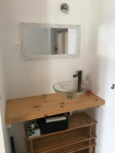 a bathroom with a glass bowl sink on a wooden counter at Domaine La Bonne Dame - Merle, au coeur des Vosges in Plainfaing