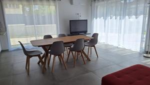 a dining room table with chairs and a television at Sweet Home Maison entière in Taverny