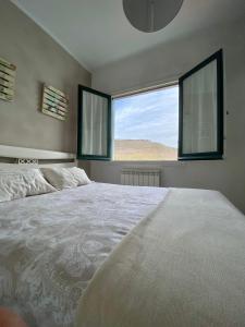 Un dormitorio con una cama grande y dos ventanas. en Apartamento Elizondo Giltxaurdi, en Elizondo