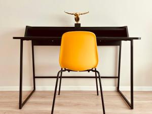 a desk with a yellow chair in front of it at Hell, gemütlich, zentral - Appartement am Dom in Braunschweig