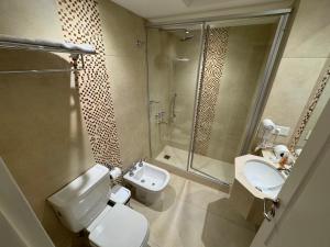 a bathroom with a toilet and a sink and a shower at Intersur Suites in Buenos Aires +26 photos