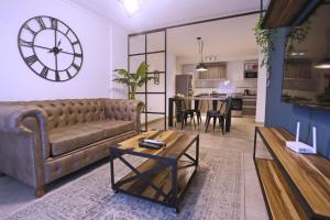 a living room with a couch and a clock on the wall at Alamos 1 A in San Miguel de Tucumán