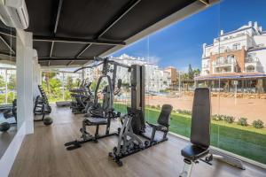 een fitnessruimte met loopbanden en cardio-apparatuur in een gebouw bij Occidental Torremolinos Playa in Torremolinos