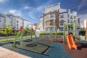 um parque infantil em frente a um edifício de apartamentos em Occidental Torremolinos Playa em Torremolinos