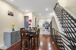 a dining room with a table and chairs and a staircase at Lovely Vacation Home In The Grays Ferry Area in Philadelphia