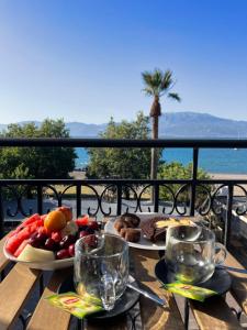 a table with two plates of food on a balcony at Regina Hotel in Nafpaktos