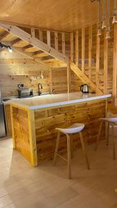 uma cozinha com paredes de madeira e um balcão com um lavatório em درة العروس اكواخ الدره em Durat Alarous