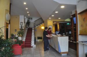 two people standing at a counter in a restaurant at Albergo Fiorenza in Salerno