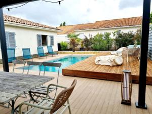 patio z drewnianym tarasem przy basenie w obiekcie Biscarrosse Bourg VILLA AVEC PISCINE w mieście Biscarrosse