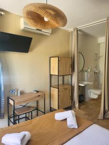 baño con cama, escritorio y lavamanos en Hôtel de la Mer, en Hyères