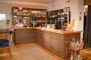 dos mujeres de pie en un bar en un restaurante en Hôtel de la Mer, en Hyères