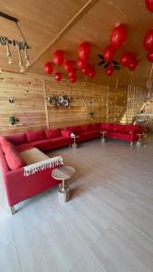 a living room with red couches and red balloons at درة العروس اكواخ الدره in Durat  Alarous