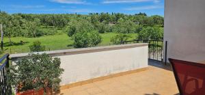 a balcony with a fence and a view of a field at Sea view apartment Renzzo in Strunjan