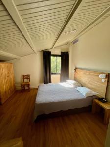 A bed or beds in a room at Logis Hotel Le Lonca
