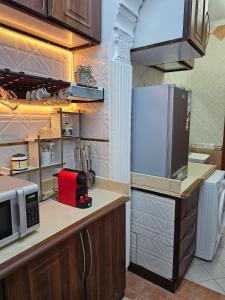 uma cozinha com um frigorífico e um micro-ondas em شقة هادئة بمساحة كبيرة بحي التنعيم بمكة المكرمة غرفة نوم واحدة فقط em Murshidīyah