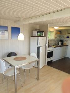 uma cozinha e sala de jantar com mesa e cadeiras em Hyttan em Åkirkeby