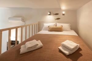 a bedroom with a bed with two towels on it at Oinoni's Home - AIAKOS studio in Souvala +12 photos