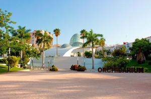 a park with benches and a building and palm trees at Encantadora casa en el corazón de Estepona in Estepona