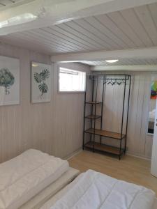 um quarto com uma cama, uma janela e uma prateleira em Hyttan em Åkirkeby