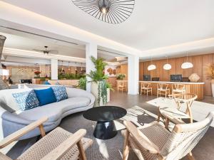 a living room with a couch and chairs and a table at Flacalco Hotel & Apartments in Cala Ratjada