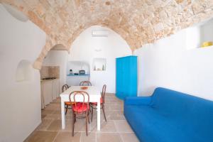 una sala da pranzo con un tavolo e un divano blu di Casa La Stella - terrazza e vista sul mare a Ostuni Altre 15 foto