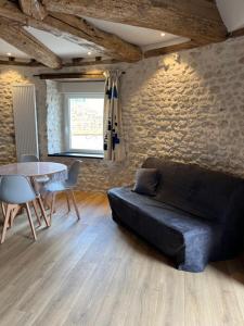 uma sala de estar com um sofá preto e uma mesa em Ferme de Mesangeon em Beauvilliers