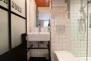 La salle de bains est pourvue d'un lavabo et d'une douche. dans l'établissement room2 Hammersmith Townhouse, à Londres