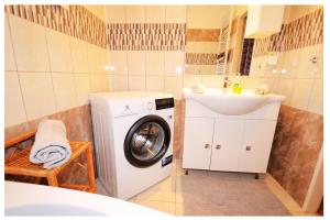 a bathroom with a washing machine and a sink at Beauty apartment in Bratislava