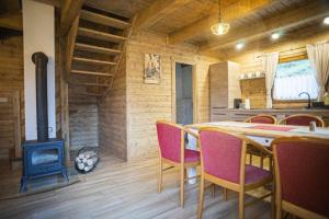 a dining room with a table and a stove at Chata pod hradom 1 in Uhrovské Podhradie
