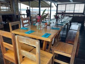 a wooden table with chairs and a long table at Dolphin Blue Paradise in Bocas del Toro