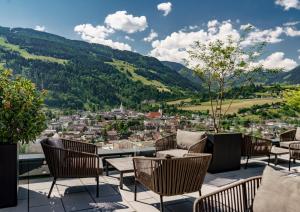 eine Terrasse mit Stühlen und Stadtblick in der Unterkunft Ferienalm Panorama Apartments in Schladming