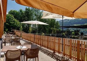 two tables and chairs with umbrellas on a patio at Ferienalm Panorama Apartments in Schladming