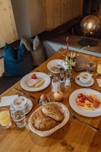 uma mesa de madeira com pratos de comida em Ferienalm Panorama Apartments em Schladming