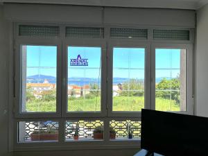 una finestra in una camera con vista sulle montagne di MIRABATEA, Piso con vistas al mar a A Pobra do Caramiñal