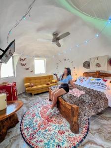 uma mulher sentada numa cama num quarto em La Bota del Gigante em Gigante