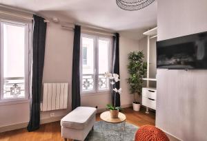 ein Wohnzimmer mit einem Stuhl und einem Tisch in der Unterkunft 833 - Charming studio in Paris Olympic Games 2024 in Paris