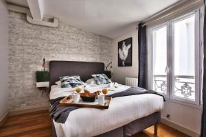 ein Schlafzimmer mit einem Bett und einem Tablett mit Essen drauf in der Unterkunft 833 - Charming studio in Paris Olympic Games 2024 in Paris
