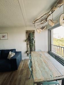 un salon avec une table en bois et un canapé dans l'établissement Sète-Vue mer-#monabridelaplage, à Sète