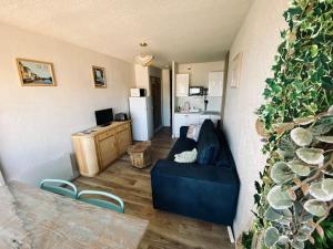 un salon avec un canapé bleu et une cuisine dans l'établissement Sète-Vue mer-#monabridelaplage, à Sète