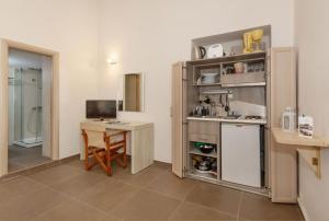 a kitchen with a table and a desk with a computer at Oinoni's Home - ACHILLES studio in Souvala
