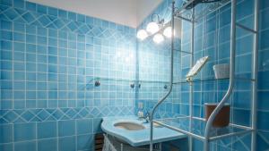 a blue tiled bathroom with a toilet and a shower at Welcomely - Natural Garden in Porto Rotondo +10 photos