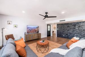 a living room with a couch and a brick wall at Sunshine, Paradise Escape! Private Pool, Sleeps 12 in Phoenix