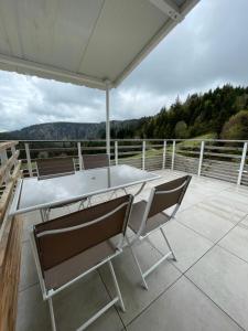 a table and chairs on a patio with a view at Beau duplex vue sur le Lac Blanc in Orbey