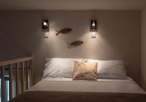 um quarto com uma cama com dois peixes na parede em Oinoni's Home - ACHILLES studio em Souvala