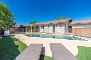 a swimming pool with benches in front of a building at Sunshine, Paradise Escape! Private Pool, Sleeps 12 in Phoenix