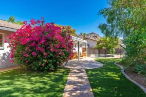 a garden with pink flowers and a walkway at Sunshine, Paradise Escape! Private Pool, Sleeps 12 in Phoenix