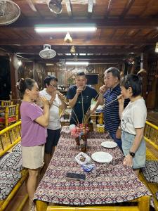 un gruppo di persone che si aggirano intorno a un tavolo di Thao Ly Homestay Mai Chau a Hòa Bình